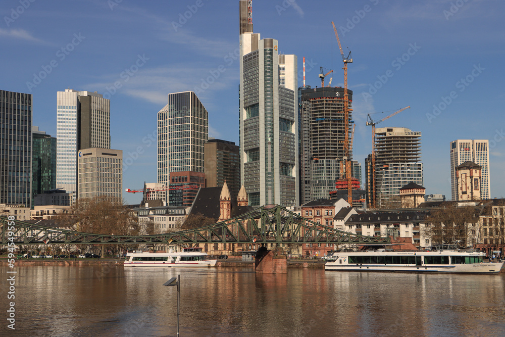 Obraz premium Frankfurt am Main; Skyline über dem Mainkai und dem Eisernen Steg im April 2023