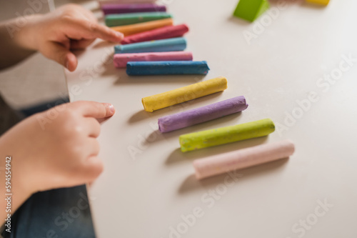 A three-year-old boy plays with crayons  plasticine and a construction set. The concept of early development and sensory perception. Finger games in kindergarten