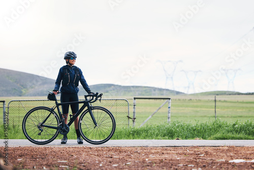 Woman, athlete and bicycle in countryside, mockup on sky and training for triathlon, sports and goals. Female cyclist, bike and fitness gear with motivation, freedom or thinking of cardio performance