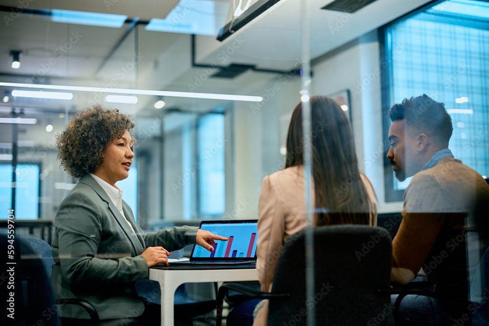 Financial consultant using laptop while talking to couple about their investment possibilities. Financial consultant using laptop while talking to couple about their investment possibilities.