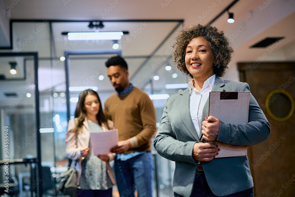 Obraz premium Happy female financial consultant in office looking at camera.