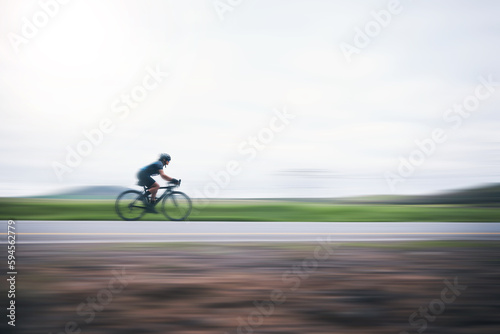 Fotografie Person cycling fast with motion blur, sky mockup and bike in countryside, triathlon and cardio training