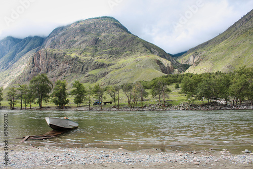 Small boat moored to a wooden pier on the bank of a mountain river  summer landscape  Altai Republic  Siberia  Russia