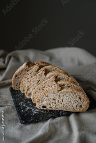 Artisan Batard Sourdough healthy Bread. Open crumb high hydration Sourdough french country bread set on dark background.
