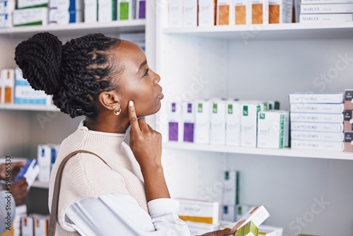 Black woman, patient and thinking for healthcare drugs, medication decision for pain relief on pharmacy shelf. Thoughtful African female customer looking at pharmaceutical products for self diagnosis
