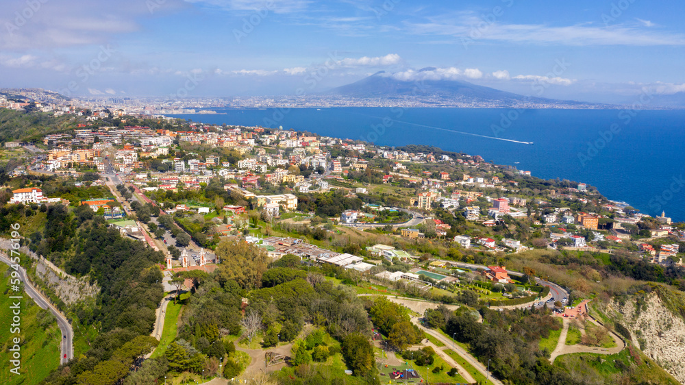 Aerial view of Posillipo district in the city of Naples, Campania, Italy. In the background the volcano Vesuvius dominates the landscape.