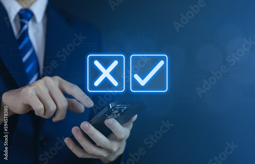 Businessman using smartphones show right and wrong symbols. yes or no decision	
