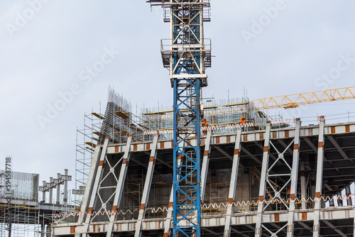 Construction of a large concrete building. Construction crane on the background of the sky. Construction site. 