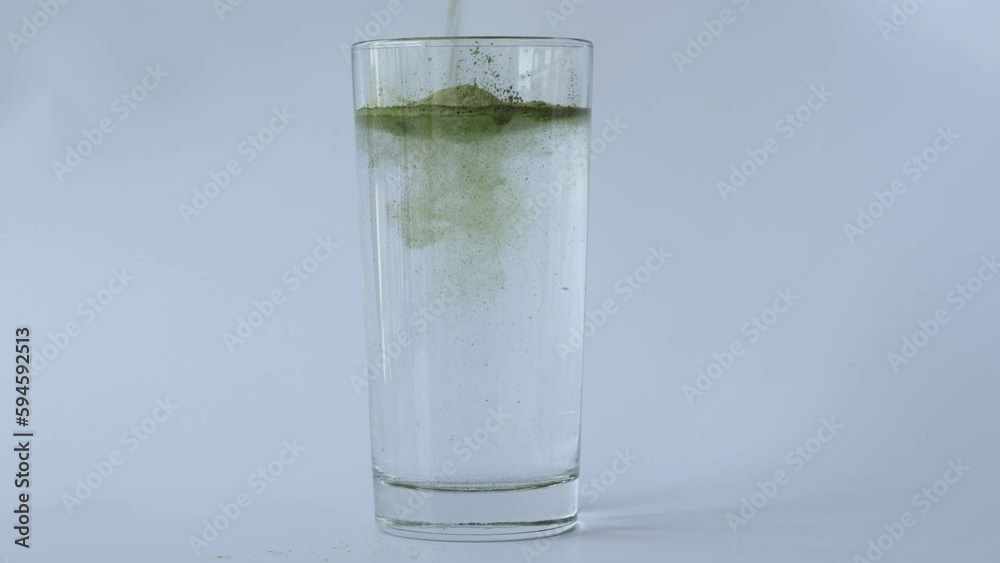 Green Vitgrass powder dissolved in a glass of water Green Vitgrass powder dissolved in a glass of water