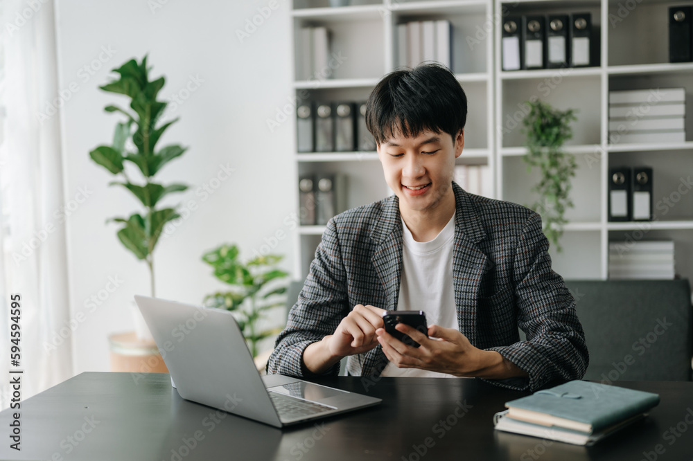 Young business man working at modern office with laptop, tablet and taking notes on the paper.. Young business man working at modern office with laptop, tablet and taking notes on the paper..