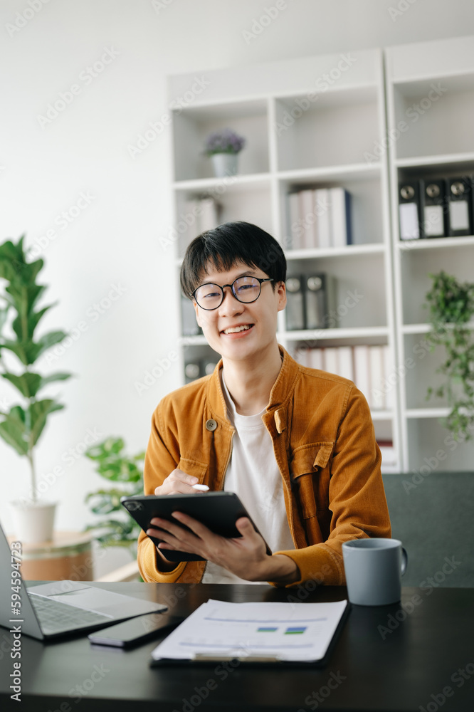 Handsome Asian business woman typing laptop and tablet Placed at the table at the modern office. Handsome Asian business woman typing laptop and tablet Placed at the table at the modern office.