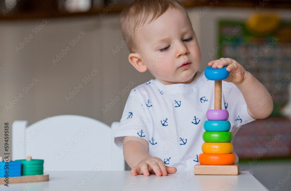 A little boy is playing educational logic games. Children's wooden toys. Sorter. Montessori for child development. A little boy is playing educational logic games. Children's wooden toys. Sorter. Montessori for child development.