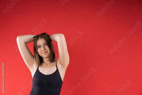 girl in black bodysuit. portrait on a red background
