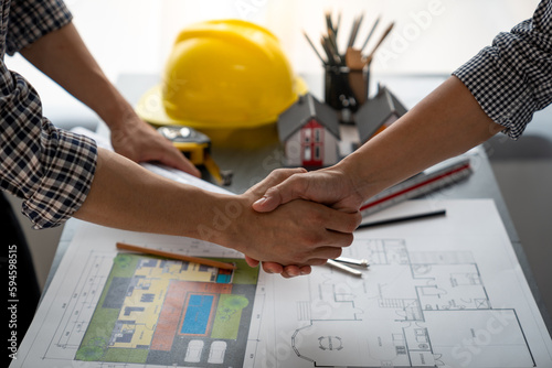 Architect and construction worker engineers shaking hands while teamwork and cooperation concept after completion of agreement on village construction project Successful Collaboration Concept.