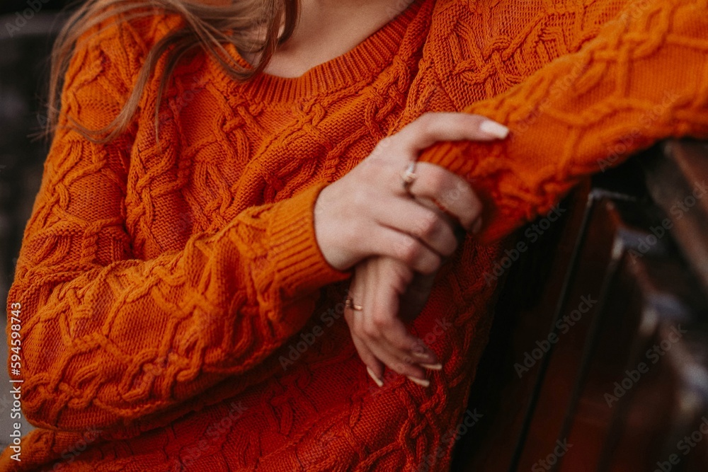 Female figure in orange knitted cozy sweater. Autumn winter street style casual cloth concept