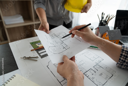 Architects, engineers, contractors discuss construction plans, site work, layout design. Plans on blueprints and technology work together in office Business start-up concept.