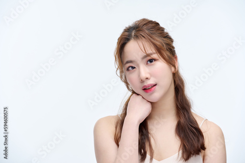 Beautiful Young Asian woman with clean fresh skin touching two hands on face in beauty pose. Pretty girl smiling in white background. Facial treatment, cosmetology, cosmetic surgery, make up concept.