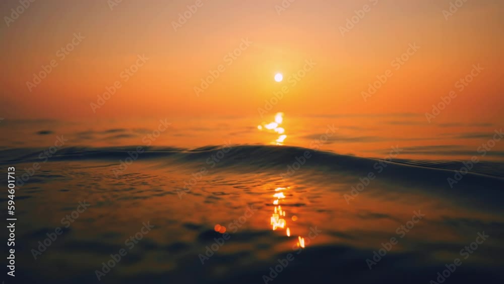 Slow Motion ocean surface from underwater at sunset with rays of light. Crystal clear breaking ocean wave with waving waterline. Sunrise over calm sea. Dawn over horizon, ocean, water - timelapse or Slow Motion ocean surface from underwater at sunset with rays of light. Crystal clear breaking ocean wave with waving waterline. Sunrise over calm sea. Dawn over horizon, ocean, water - timelapse or