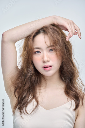 Beautiful Young Asian woman with clean fresh skin touching two hands on face in beauty pose. Pretty girl smiling in white background. Facial treatment, cosmetology, cosmetic surgery, make up concept.