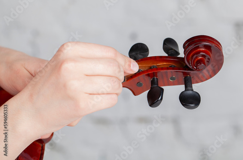 Fotografía Violin on studio background. String stretching process.