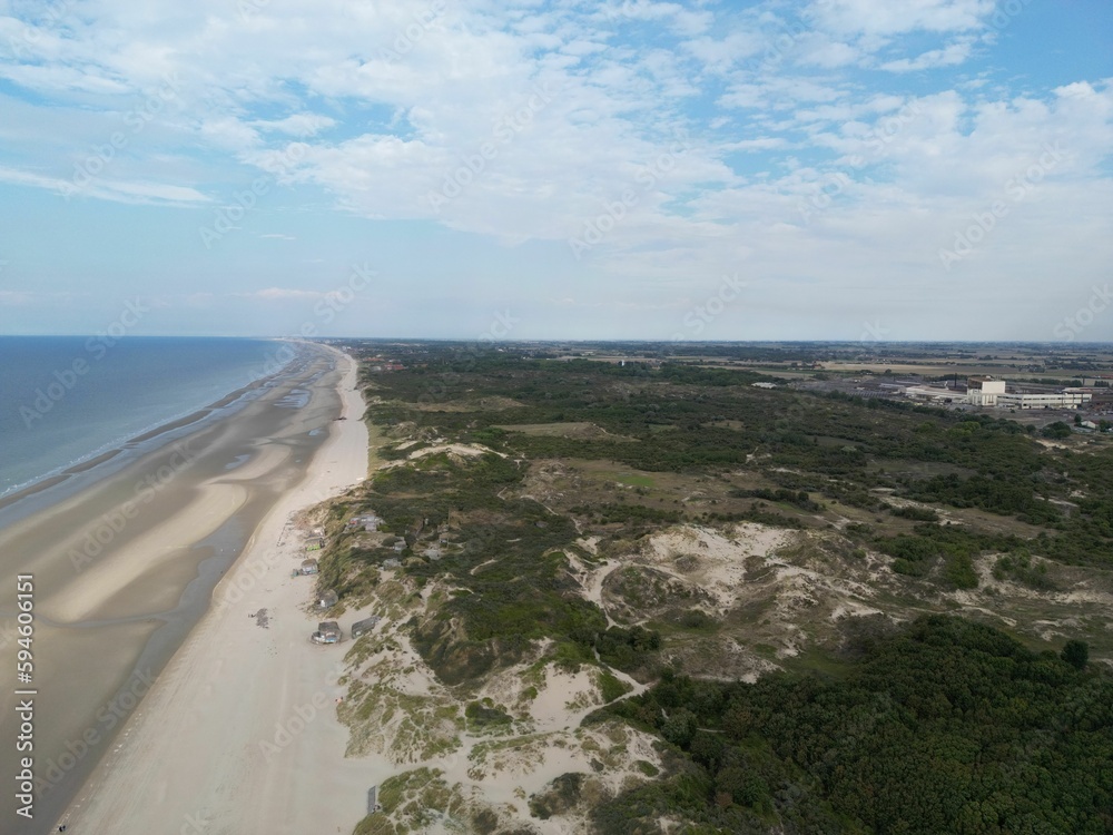 Fototapeta premium Aerial view of a beach in Dunkerque (Dunkirk), France with lush green vegetation on the shore