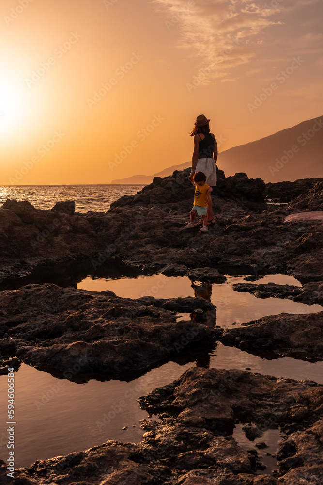 Mother and son at sunset on Tacoron beach on El Hierro, Canary Islands