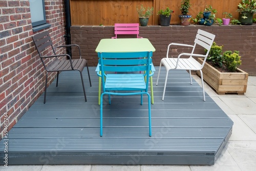 Newly built and painted gray with colorful furniture wooden deck in back garden. © Jakub Rutkiewicz/Wirestock Creators