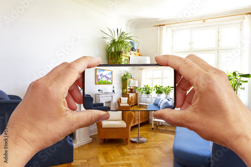 Augmented reality concept: hands holding smart phone with AR interior decoration app, visualising the living room with additional photo frame. photo