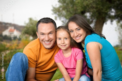 Happy young parents with cute child walking outdoors © BillionPhotos.com