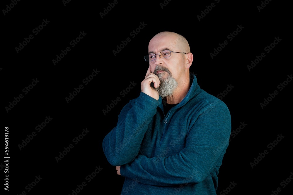 Caucasian man with a bald head and a goatee, holding his chin thoughtfully, copy space