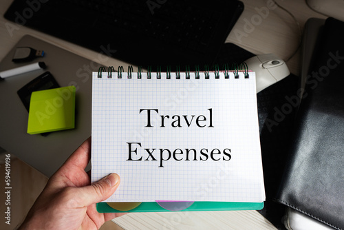 Travel expenses word on notebook holding man against desktop. photo