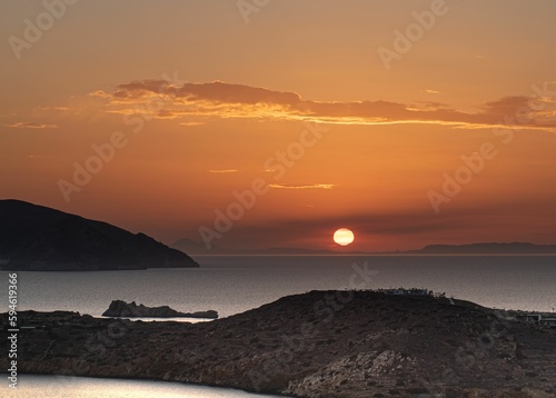 Sunset over some mountains and water with a sunset in the distance