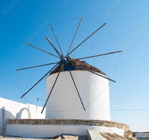 White windmill on the side of the road near a building
