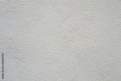 A white wall with a rough textured surface.