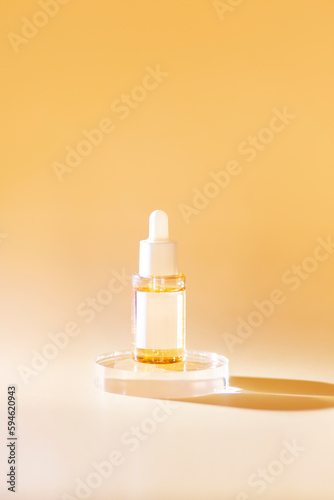 Yellow bottle with pipette with essential oil on yellow background top view. Aromatic cosmetic product for skin and hair care Moisturizing beauty product with vitamin C. Flatlay.