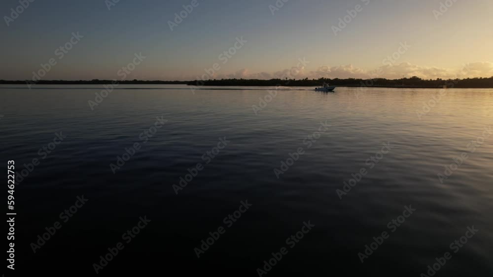 Aerial of a boat sailing in the calm ocean at North Palm Beach, Florida during the golden sunset Aerial of a boat sailing in the calm ocean at North Palm Beach, Florida during the golden sunset