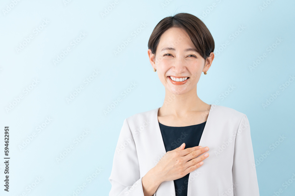 笑顔で胸に手を添えるビジネスウーマン 笑顔で胸に手を添えるビジネスウーマン