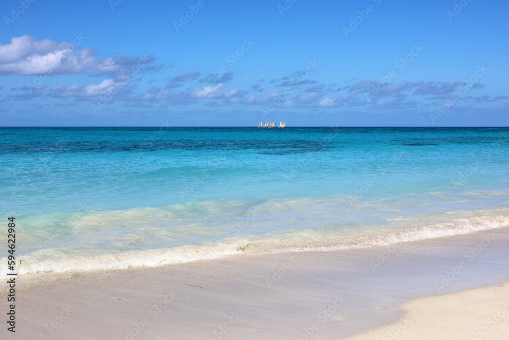 Tropical beach with white sand on a ocean, view to blue waves and sky. Background for holidays on a paradise nature