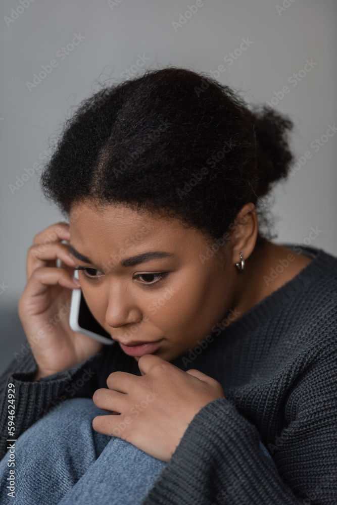 Young multiracial woman with depression calling in helpline at home. Young multiracial woman with depression calling in helpline at home.