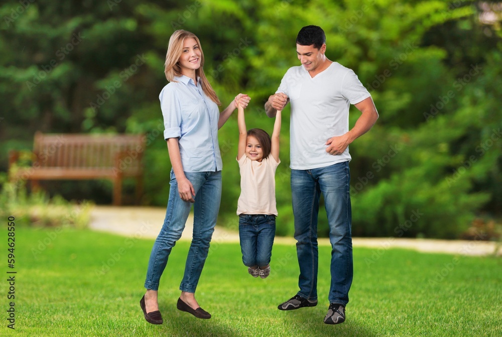 Happy young parents with cute child walking outdoors