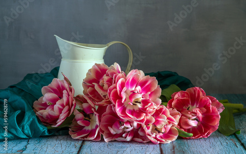 Still life with beautiful red-white tulips and a jug.