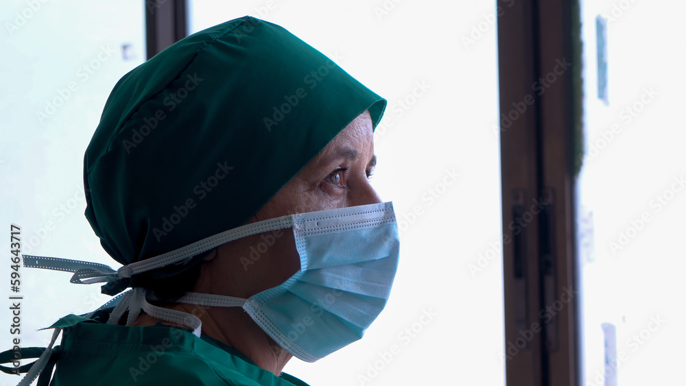 Close-up doctor's face, one wearing green hat is a hat that is only available in operating room of doctors, Mass covering nose and mouth, for cleanliness in preparation for surgery