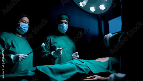  Female nurse is covering patient in bed with green, perforated cloth, cover only area needs surgery, for ease surgery doctor's, assistant did it before doctor came in for surgery prepare.