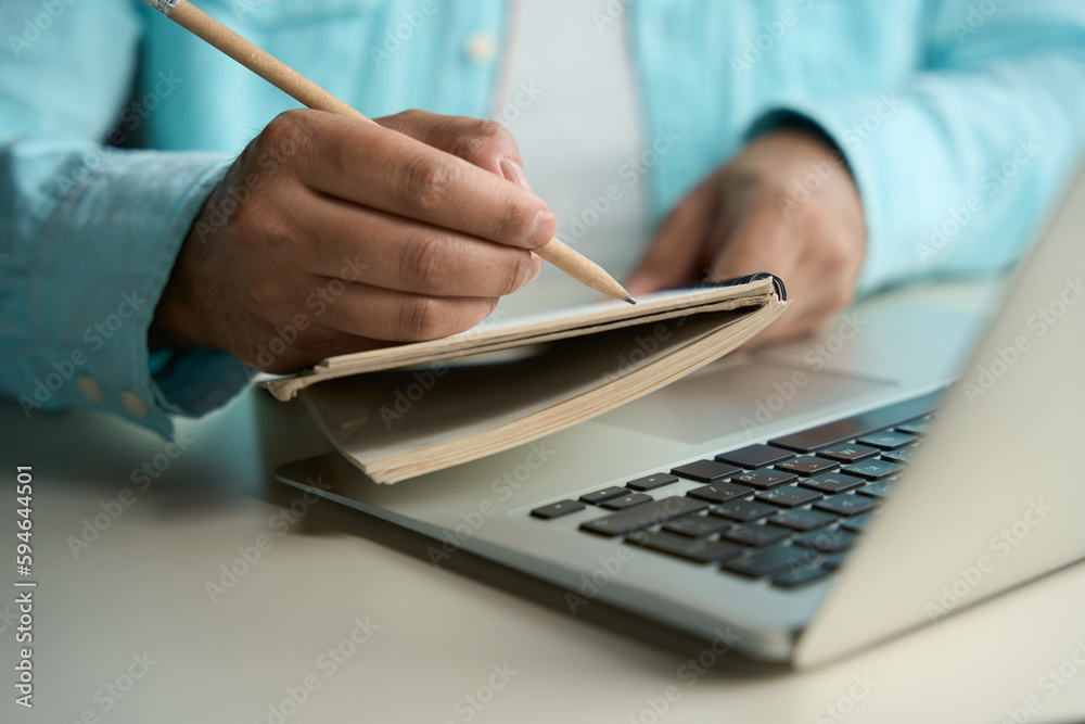 Fototapeta premium Man writing in notebook in the business center