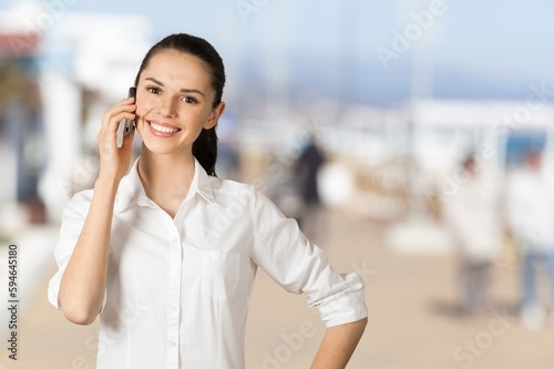 Free Download Happy young woman posing outdoors and using smartphone. - GFXLoad