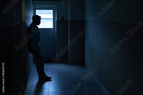 Figure of man standing in darkness and waiting