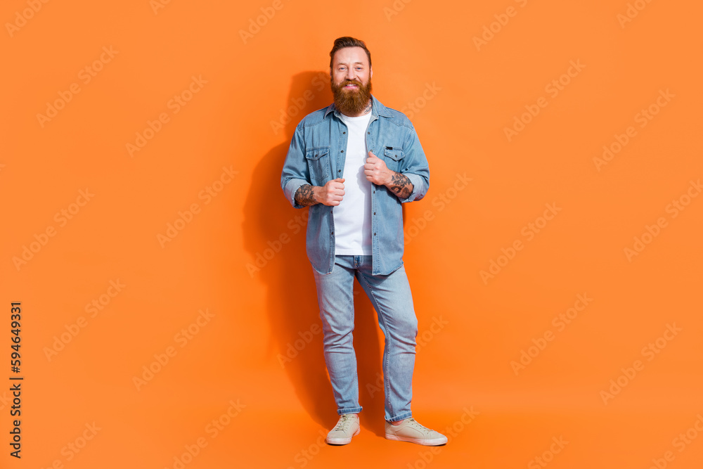 Full body photo of brutal masculine young irish hipster guy wear denim stylish outfit posing model shopping promo isolated on orange color background Full body photo of brutal masculine young irish hipster guy wear denim stylish outfit posing model shopping promo isolated on orange color background