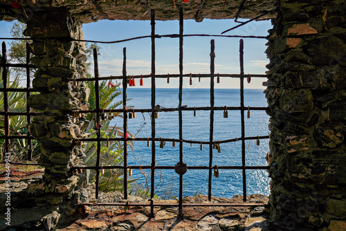 rostiges Gitter am Fenster mit Vorhangschlössern dran und Blick auf das Meer