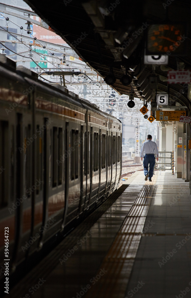 Fototapeta premium 名古屋駅のホームの電車と一人の乗客の姿