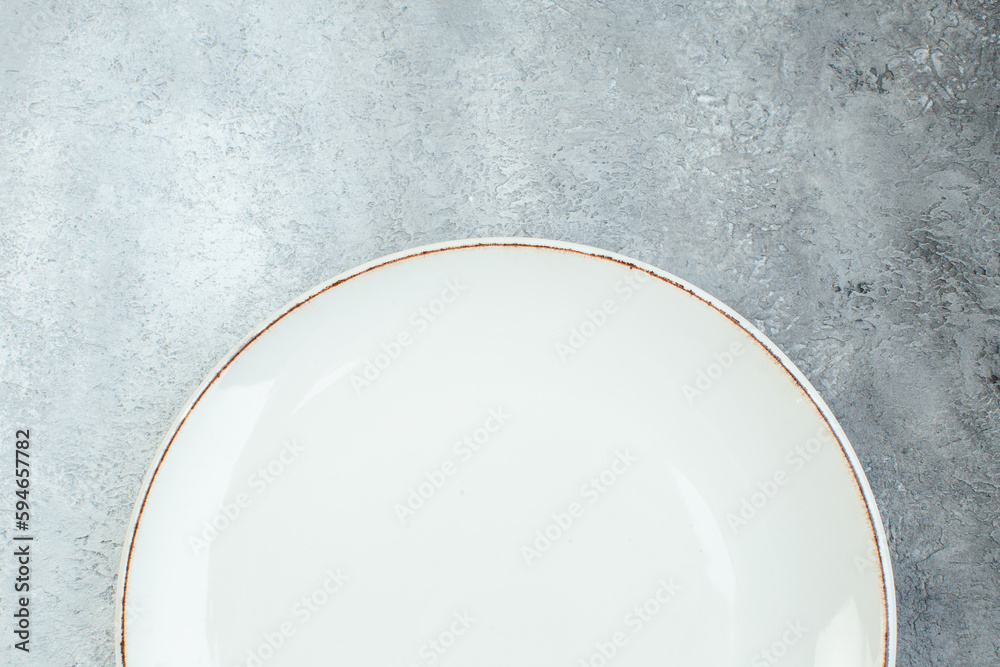 Half shot of white empty plate on gray background with distressed coarse-grained gradient surface Half shot of white empty plate on gray background with distressed coarse-grained gradient surface
